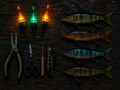 A flat-lay arrangement of fishing gear on a dark wooden surface, including three floating lures with glowing orange and green lights, four fish-shaped fishing lures, a pair of pliers, scissors, a small tool, and a folding knife.